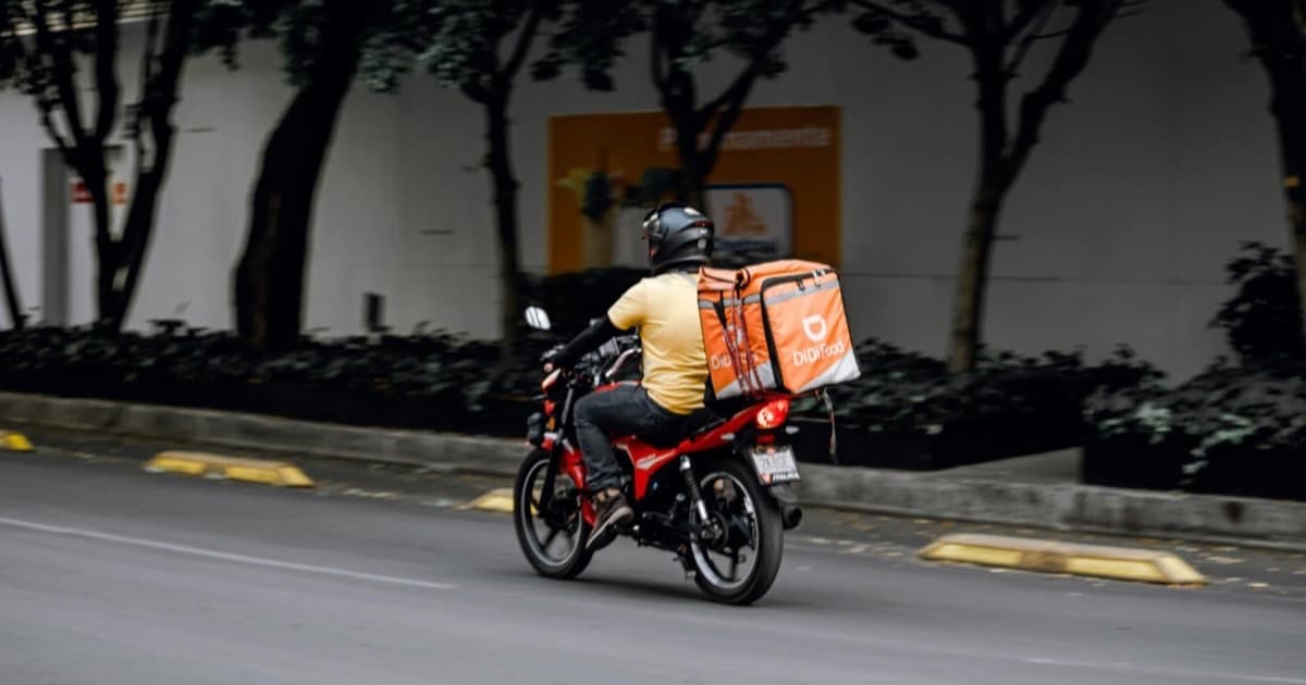 Repartidor en motocicleta realizando delivery durante pico de demanda en Semana Santa