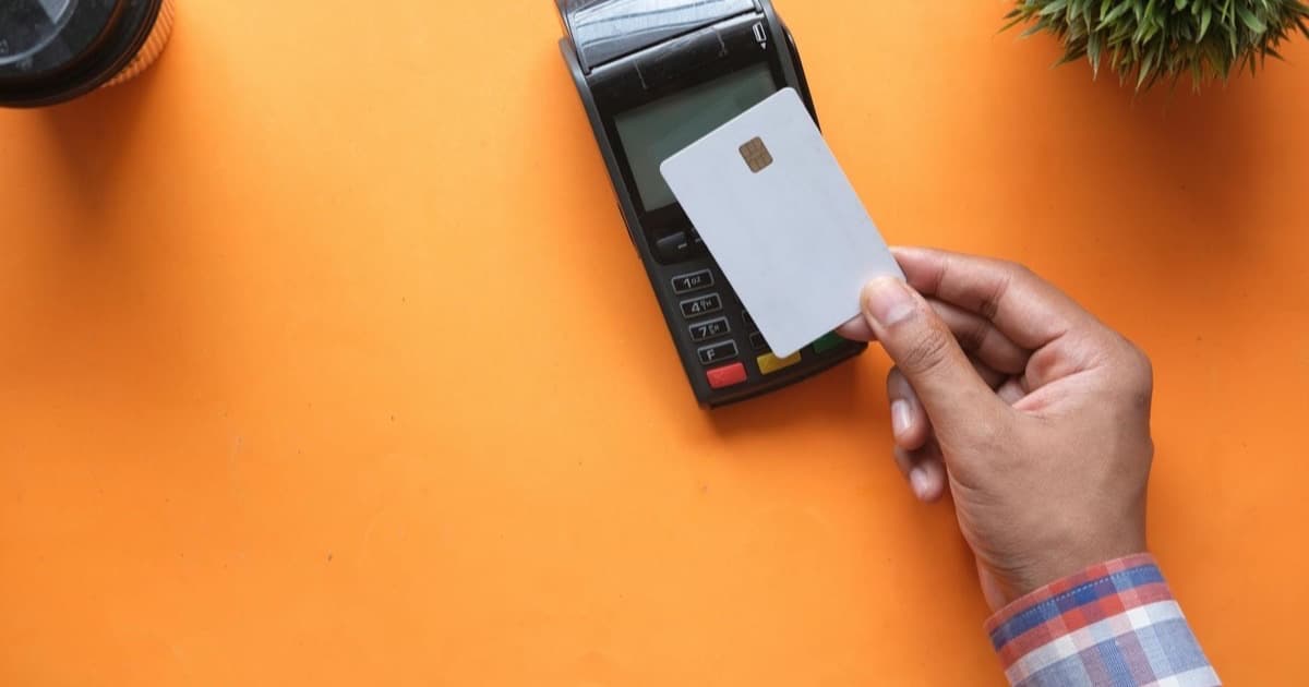 Cliente realizando pago sin contacto NFC en terminal POS moderno en tienda
